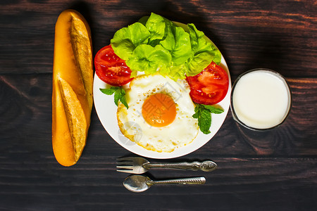 面包炒鸡蛋牛奶和蔬菜早餐以及木本面的煎番茄饼图片