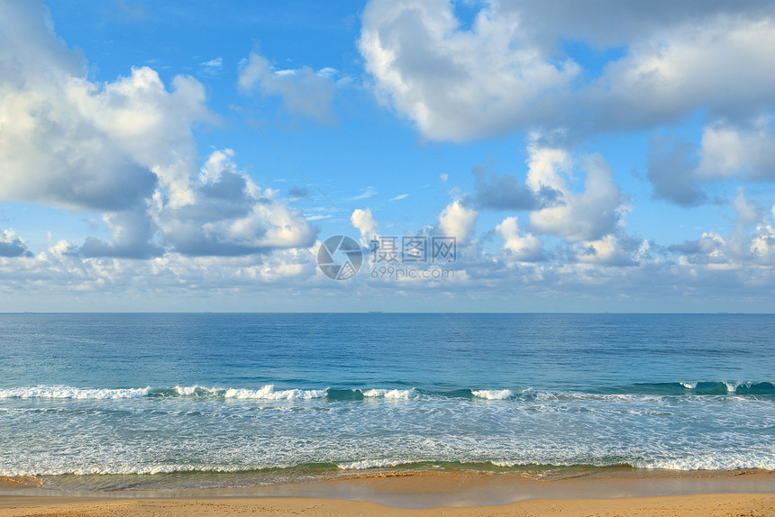 海边晴朗的阳光明媚一天黄沙和蓝海在天空的背面图片