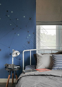 现代式床铺和蓝墙卧室的Beige和现代型床铺及薄膜上带条纹枕头的Beige和条纹枕头背景图片