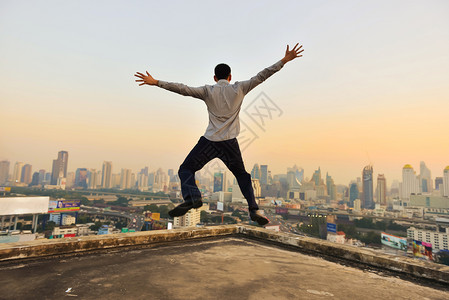 成功商人在日落时曼谷市观看成功商人举手在日落时曼谷市观看举手图片