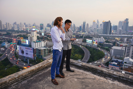 b商业人员集团在城市背景模糊商业技术概念模糊的屋顶上工作图片