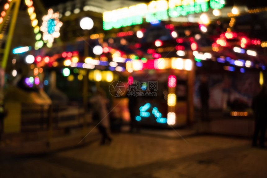 模糊街道的画面夜晚有节庆灯和旋转木马图片