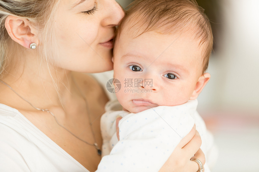 年轻女人亲吻她3个月大的男婴肖像图片