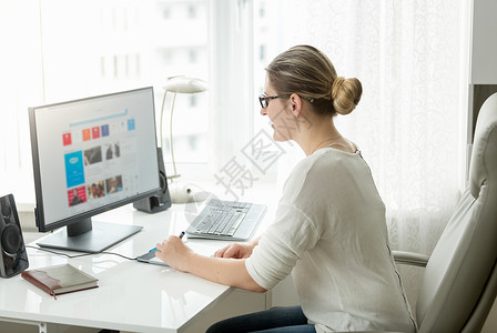 在办公室用大窗的电脑工作漂亮的女士在办公室用大窗的电脑工作图片