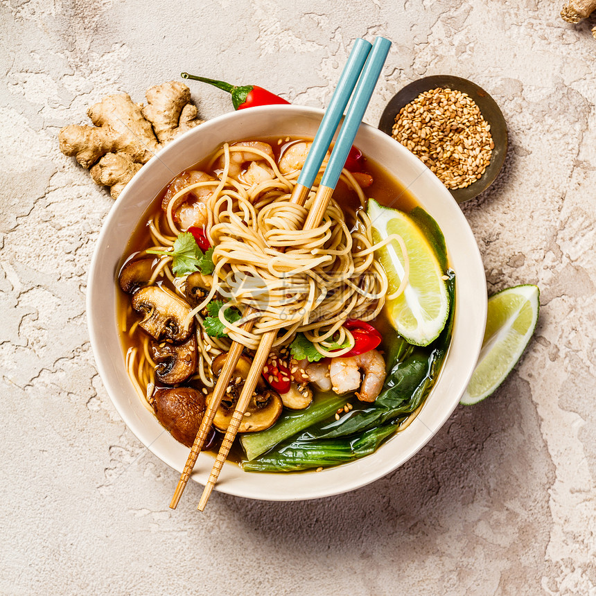 亚洲汤面条豆酱青菜蘑菇和虾在石桌上有筷子姜和石灰亚洲汤面条图片