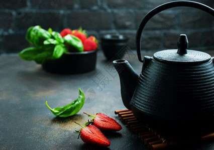 茶壶加新鲜的面包和草莓新鲜的药茶背景图片