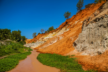 在岩石与丛林中越南梅内之间的小溪峡谷红河橙色高清图片素材