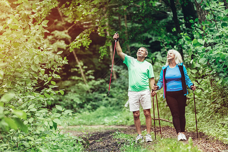 欣赏自然和在树林中行走的老年夫妇运动生活方式欣赏自然和行走的老年夫妇图片