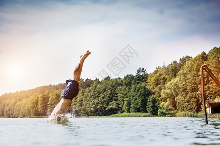 年轻人潜入湖中漫不经心冒风险的跳水暑假危险户外活动侧视背景图片