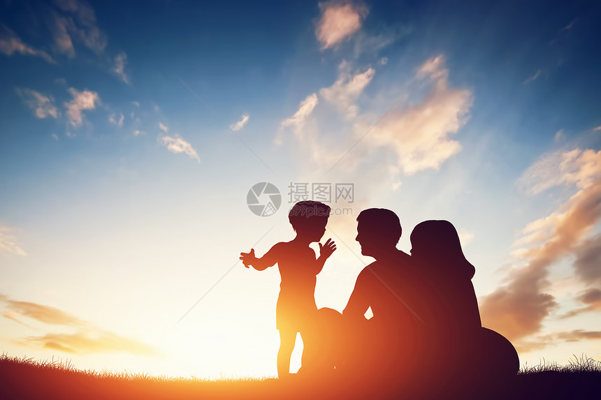 幸福的家庭在一起父母和他们的小孩在日落时坐草地上幸福的家庭在一起父母和他们的小孩在日落时一起图片