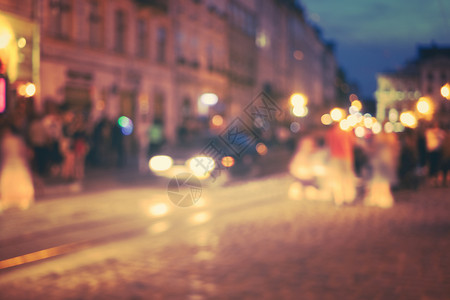 一群人走在旧的欧洲城夜街上焦点模糊的抽象图像图片