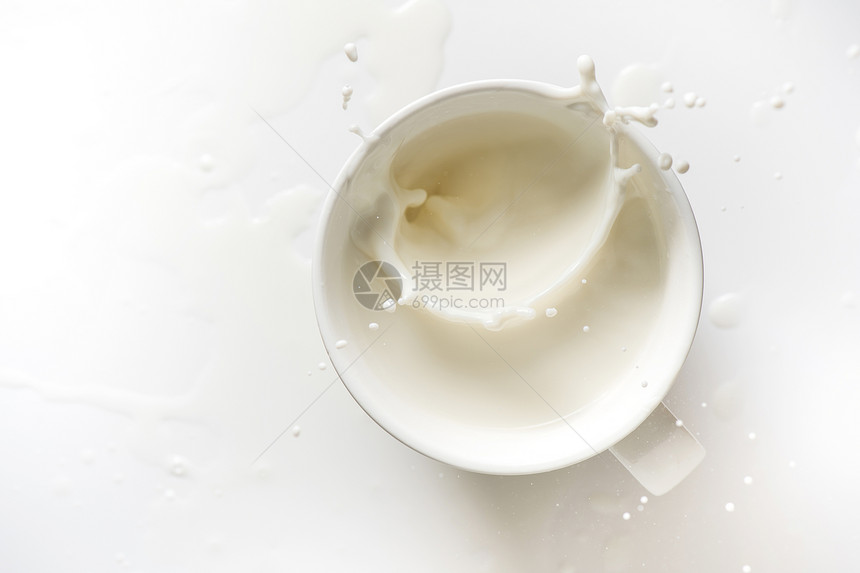 白色背景的牛奶喷出玻璃顶部视图图片