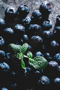 厨房柜台上洒着绿叶子的新鲜蓝莓超食品甜果新鲜蓝莓柜台上绿色叶子图片
