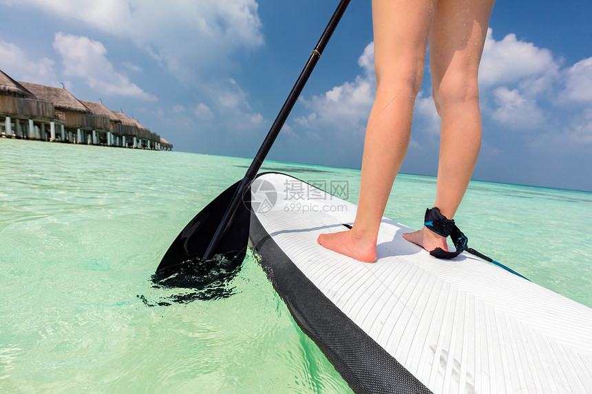 妇女在马尔代夫的海洋上站着划船桨图片