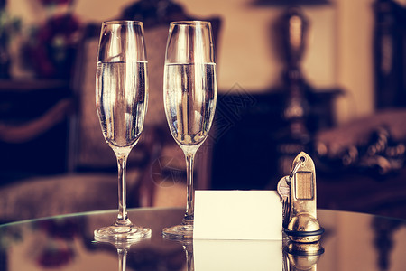 全套香槟杯古董钥匙和空白卡豪华酒店公寓客房服务概念旧式背景图片
