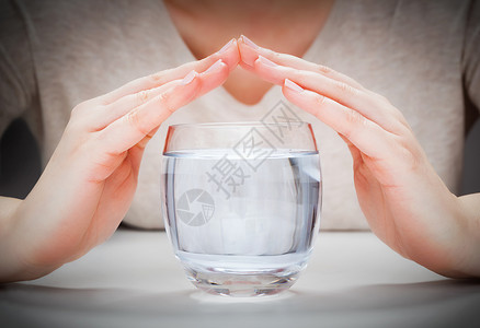 妇女与手覆盖的清洁矿泉水一杯环境保护概念健康饮品妇女与手覆盖的清洁矿泉水一杯背景图片