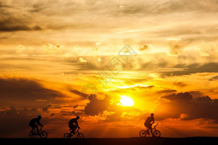 日落时骑自行车的朋友们积极生活方式骑自行车的爱好由和健康图片