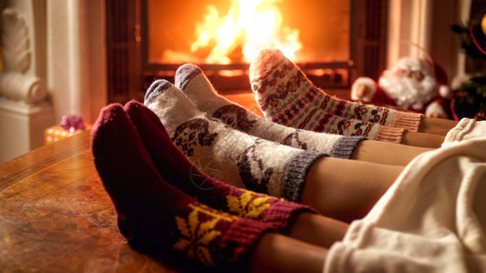 家庭在壁炉加热的针织羊绒袜子贴近照片图片