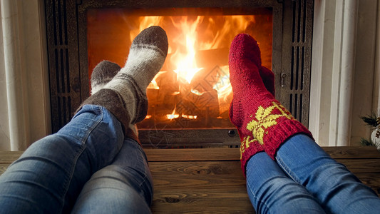 浪漫情侣牛仔裤和羊绒袜子在家中燃烧着的火升温近照图片