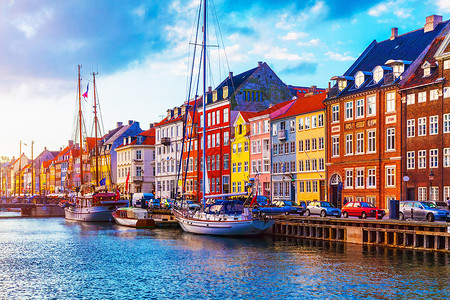 在丹麦哥本哈根老城的Nyhavn码头有彩色建筑物船只游艇和其他船只的色状建筑物游艇和其他船只的景色夏日夕阳风景尼哈文高清图片素材