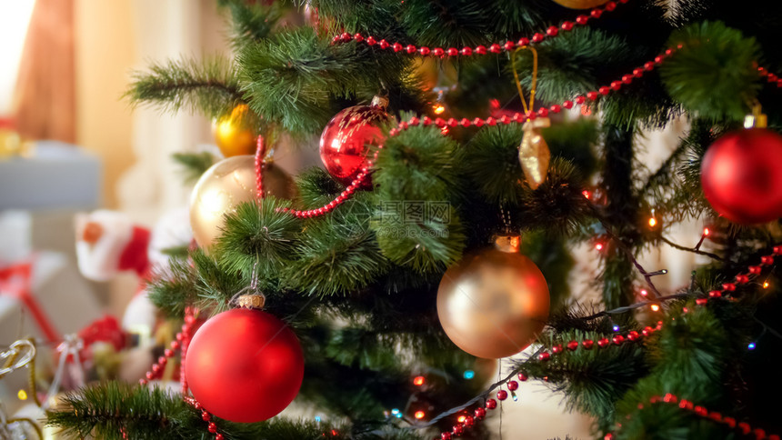 在客厅的圣诞树上挂着多彩的灯光和露珠近照在客厅圣诞树上挂着多彩的灯光和露珠近照图片