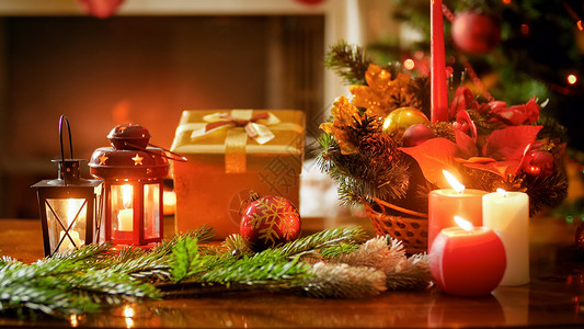 木制桌上燃烧蜡烛礼品盒和圣诞花圈的近照圣诞节高清图片素材