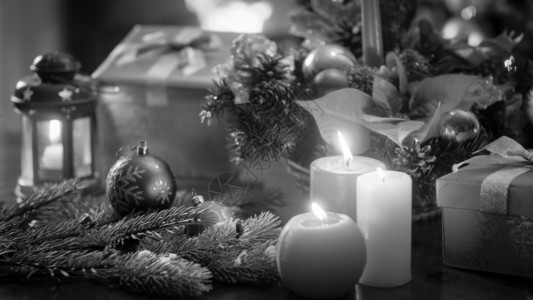 美丽的圣诞装饰和木桌蜡烛的黑白照片图片