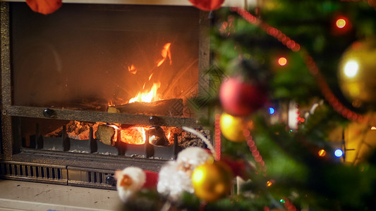 在圣诞树旁边的客厅燃烧壁炉在装饰圣诞树的旁边客厅燃烧壁炉图片