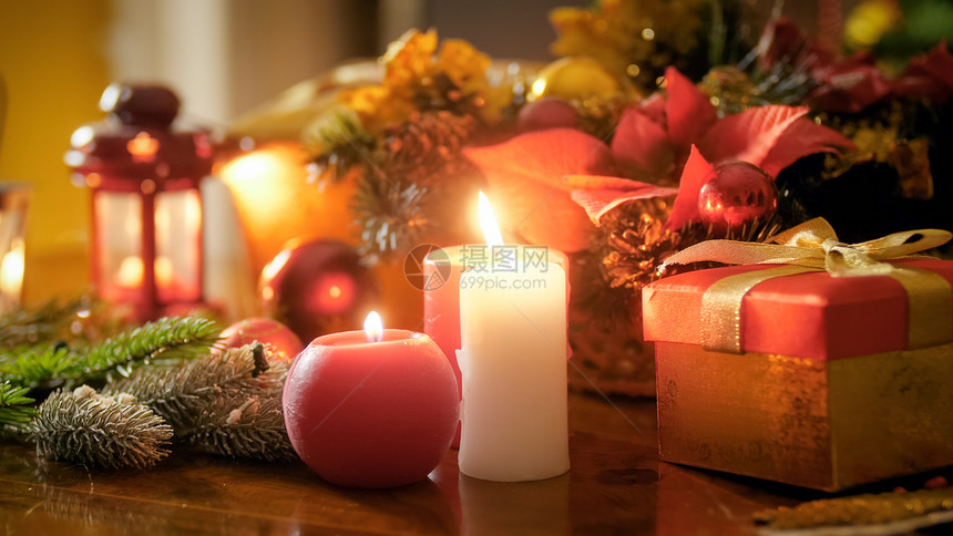 在木板上与圣诞花圈对着木板上燃烧蜡烛的紧贴照片