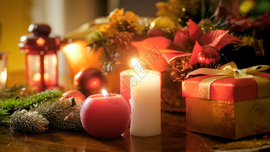 在为圣诞节装饰的桌子上有烧蜡烛和礼品的盒子中烧蜡烛和礼品紧贴照片在为圣诞节装饰的桌子上有烧蜡烛和礼品的盒子中紧贴图像冬天高清图片素材