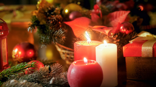 木板上三根烧蜡烛和美丽的圣诞花圈近照金色的高清图片素材
