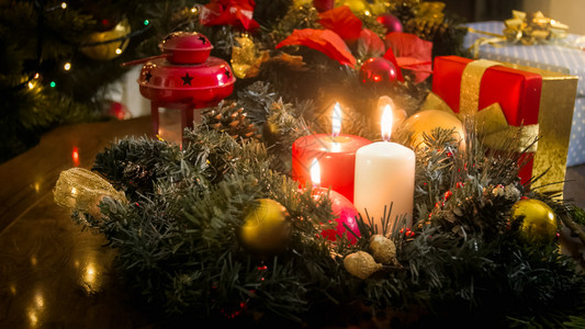 为庆祝圣诞节而装饰的木桌蜡烛上三根烧着的胶片黑暗的高清图片素材