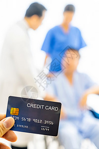 持有带医疗保险概念院背景的信用卡图片