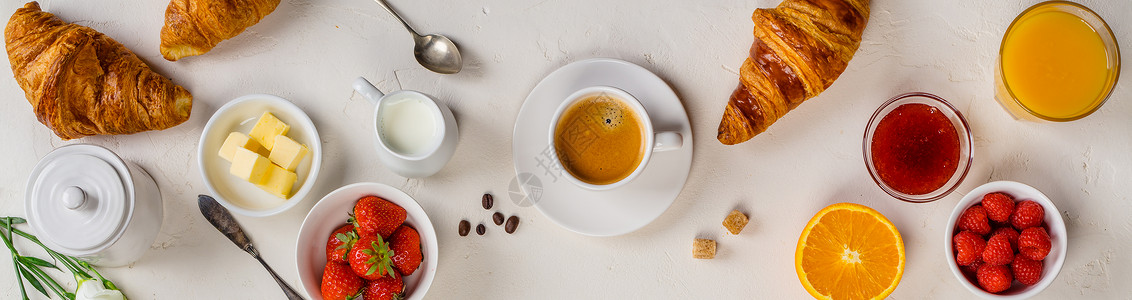 咖啡橙汁羊角面包果酱莓牛奶和鲜花图片