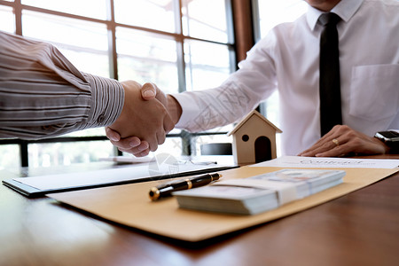 商业人员与房地产代理商签订交易合同顾问概念和家庭保险住宅的高清图片素材