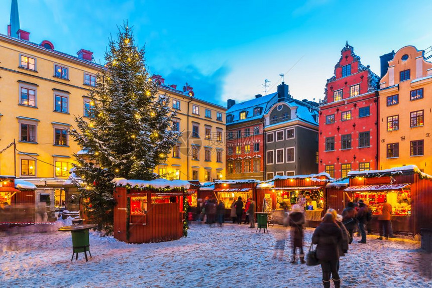 在瑞典斯德哥尔摩老城GamlaStan大广场Stortororget举行圣诞节日展会的美丽寒冬雪风景图片