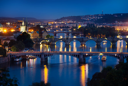 日落时伏尔塔瓦河上布拉格的照明桥图片