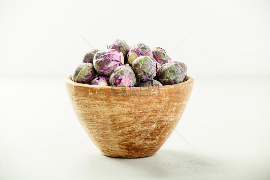 紫色布鲁塞尔芽在混凝土背景的木碗中发芽Vegan无谷质过敏清洁饮食或原始图片