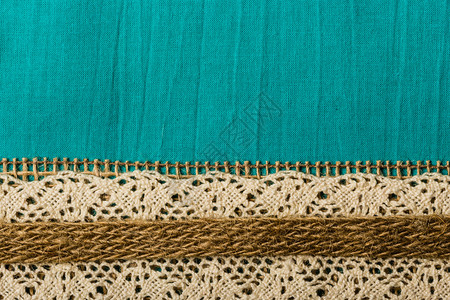 绿色蓝纺织品背景上的白色带和卷轴绳图片