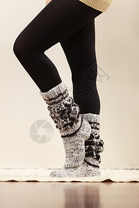 冬季时穿冬服装的妇女双腿羊毛暖和袜子黑色紧身裤穿羊毛袜子和黑色紧身裤的妇女双腿背景图片