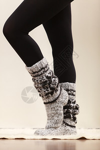 冬季时穿冬服装的妇女双腿羊毛暖和袜子黑色紧身裤穿羊毛袜子和黑色紧身裤的妇女双腿背景图片