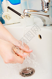 卫生洗手妇女在卫生间自来水下洗手图片