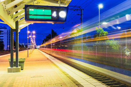 铁路旅行和运输业商概念夏季夜视高速客运列车从火站平台驶离运动效果模糊图片