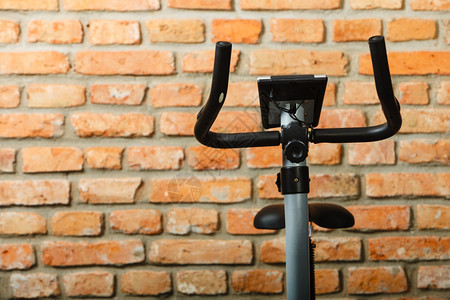 在健身中心用墙壁背景的固定训练单车在健身中心进行固定训练习背景图片