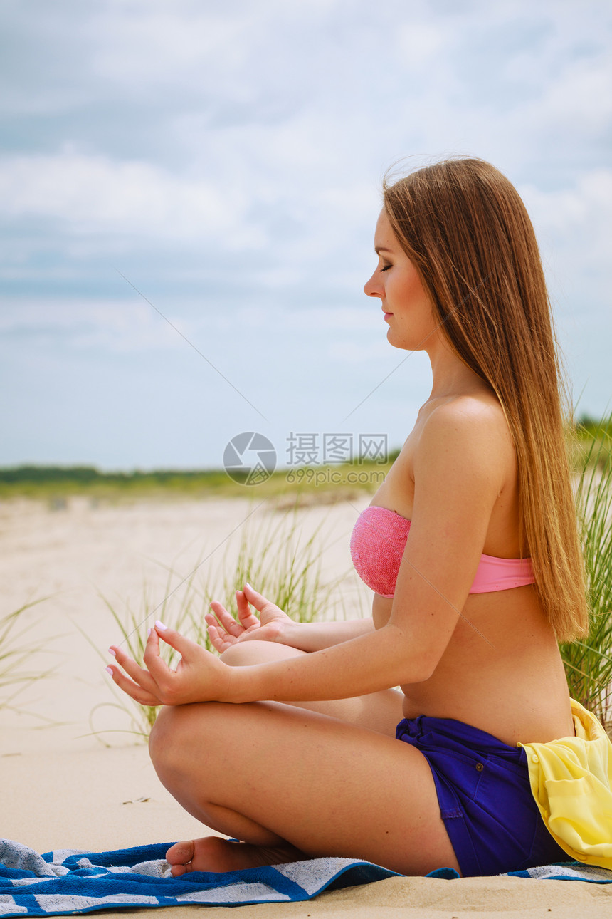 放松时间年轻女孩在瑜伽练习上闲暇时间放松身体和精神夏天在海滩上休息女人在沙滩上做瑜伽图片