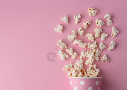 粉红背景的爆米花电影和娱乐概念图片