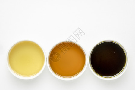织锦缎黑孜然从鳄梨、黑籽和中提取的健康油 -白画布上陶瓷碗的顶层视图,并有复制空间背景