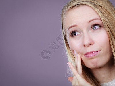 有牙痛的妇女摸着脸颊看牙医后感觉很不好图片