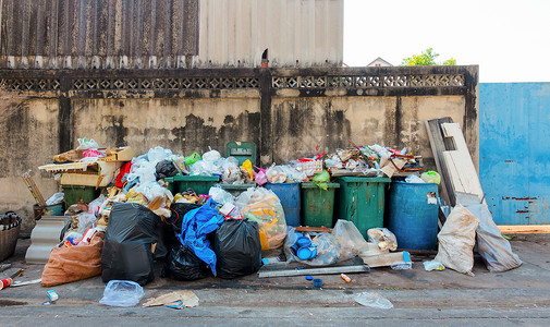 垃圾堆素材在泰国曼谷市城一堵墙附近存放各种类型的大垃圾堆塑料袋和垃圾桶采用环境污染概念背景