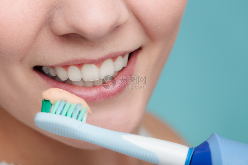 快乐的女子清洁她口腔关心牙科健康图片